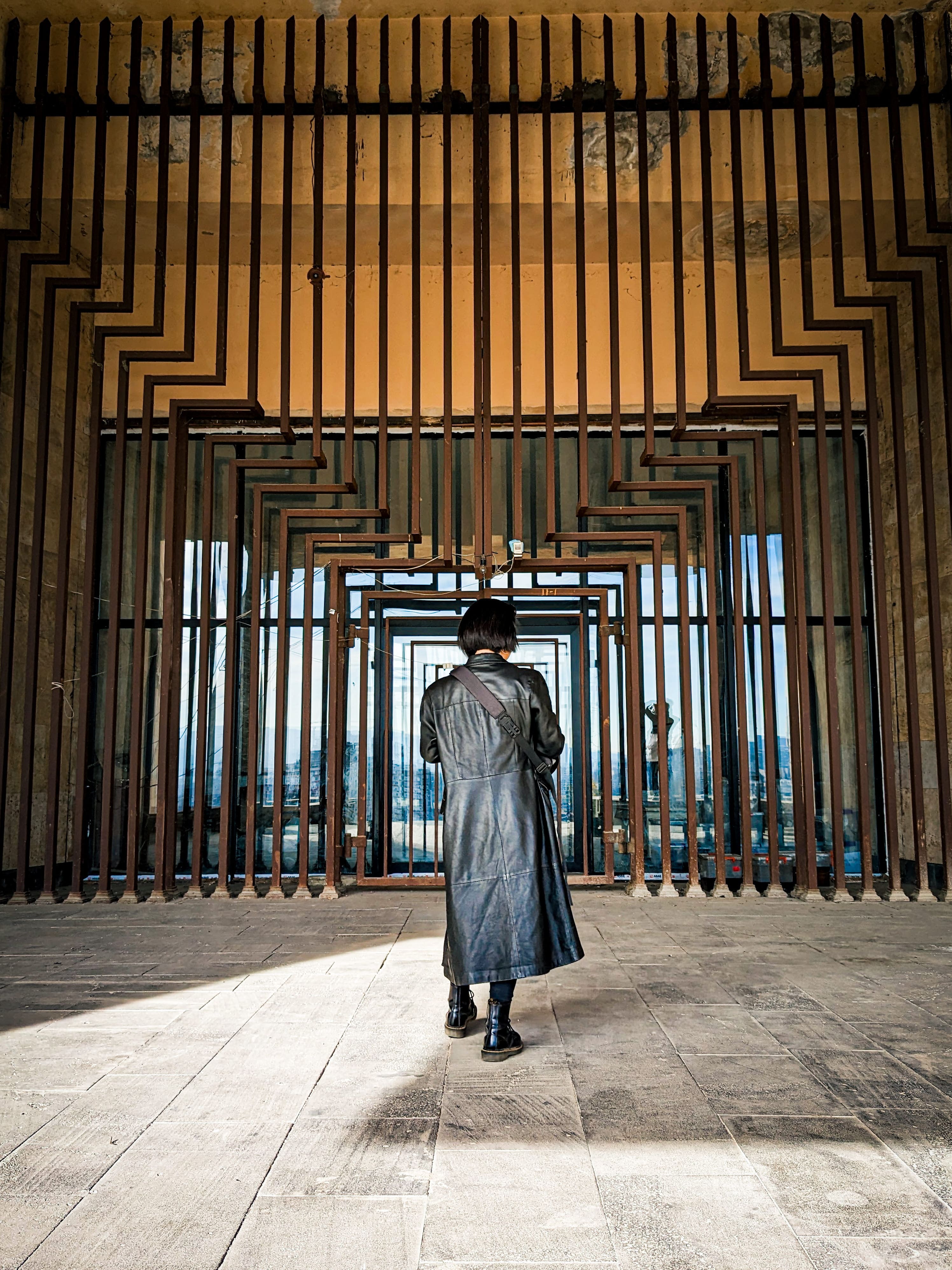 A person walking through dynamic Soviet concrete gates
